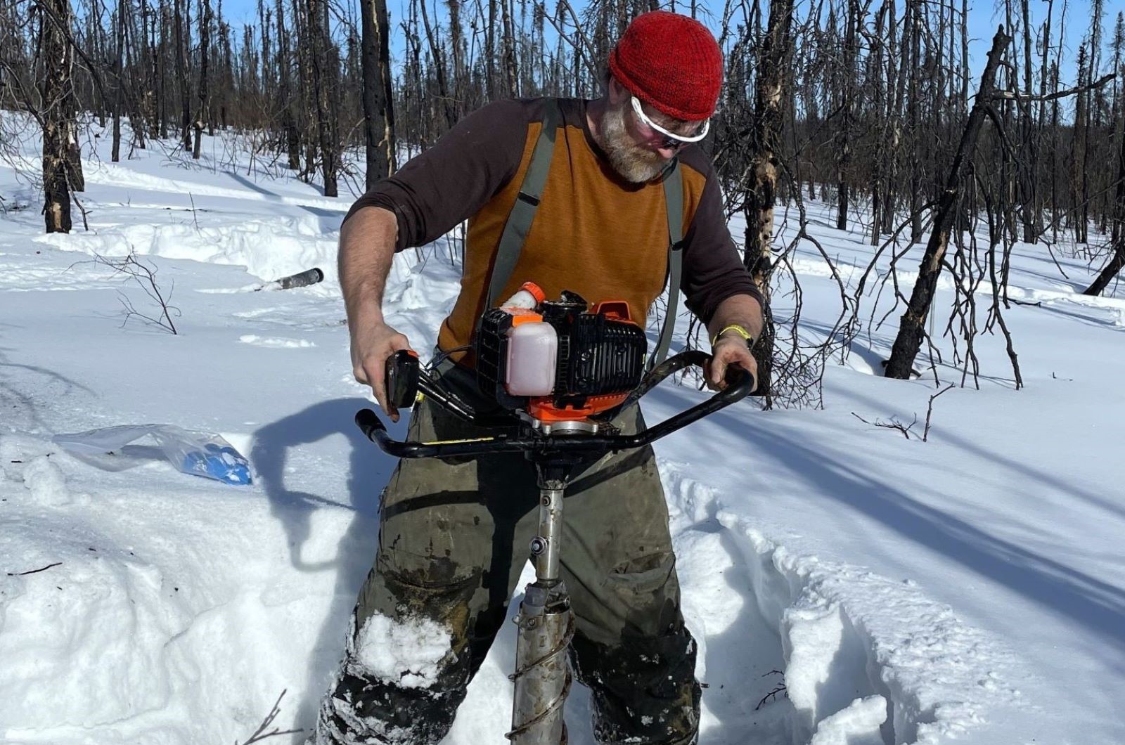 Retrieving a frozen soil core from a recently burned forest
